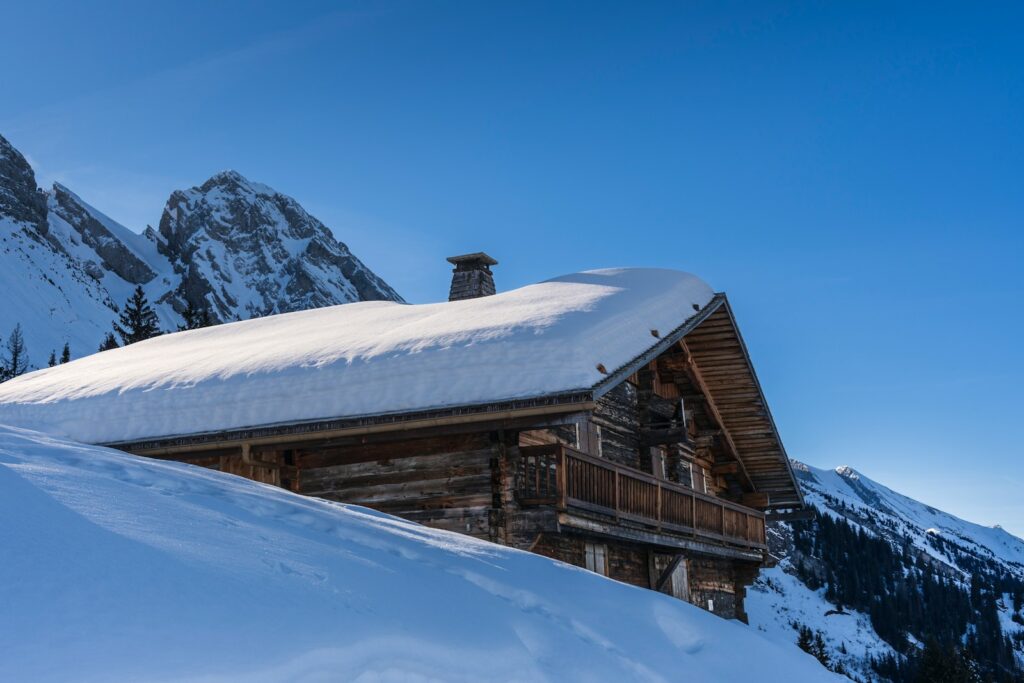 a cabin in the mountains covered in snow